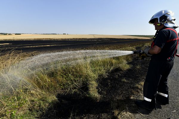 Pompier intervenant sur un feu sur des terres agricoles. Photo d'illustration.