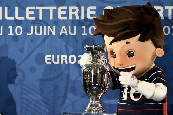 Super Victor, la mascotte de l'Euro 2016, pose à côté du trophée, le 12 mai 2015, à Paris.