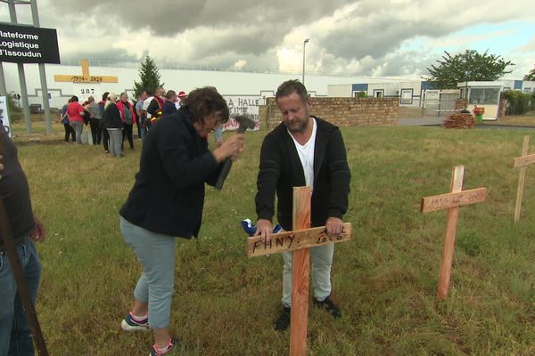 Brigitte plante une des croix qui symbolisent les emplois en sursis du dépôt logistique de la Halle à Issoudun dans l'Indre