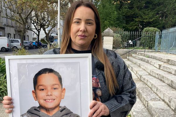 La maman de Nolan avec le portrait de son fils devant le tribunal de Privas.