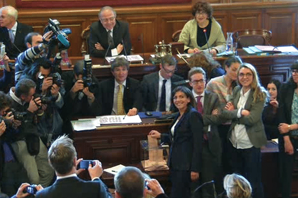 Anne Hidalgo glisse son bulletin dans l'urne du Conseil de Paris pour devenir la 1ère femme maire de la capitale.