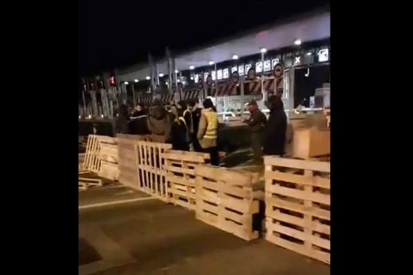 Une barrière de palettes de bois installée par des "gilets jaunes" vendredi soir au péage d'Antibes.