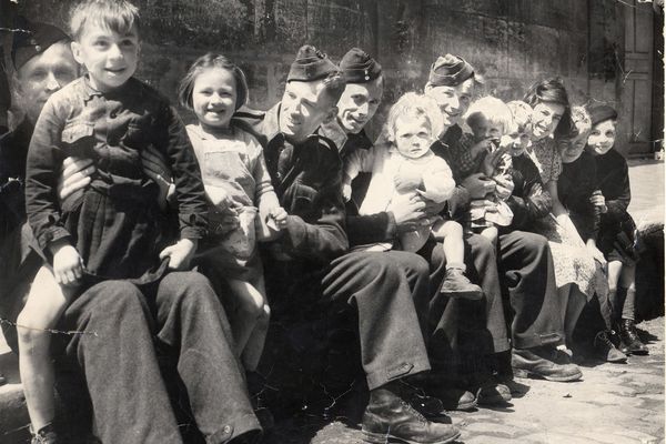 Débarquement en Normandie en 1944. Des personnels de la RAF au repos avec des enfants à Bayeux, dans le Calvados.