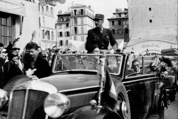 Le général de Gaulle est salué par la foule durant sa traversée de Nice en voiture, le 14 septembre 1948.