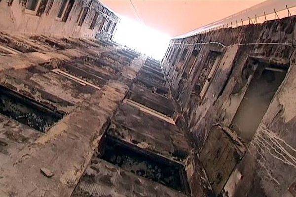 Sous la bâche, la façade sud du foyer Adoma porte encore les stigmates du terrible incendie de 2010