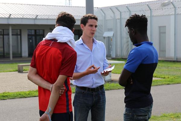 Paul Chiron, intervenant juridique pour la CIMADE dialogue avec deux jeunes retenus au centre de rétention administrative