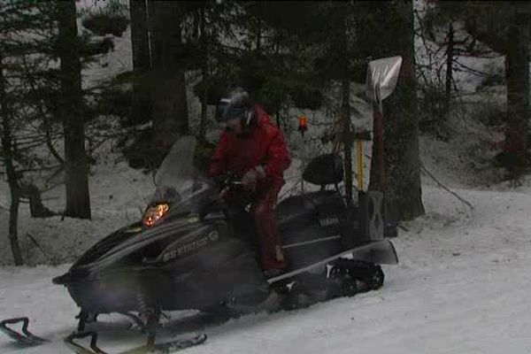 En moto-neige pour entretenir le parcours de ski nordique.