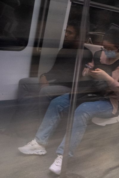 Une femme sur son portable dans le métro parisien