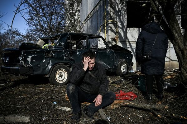 Un homme est assis devant son bâtiment détruit après les bombardements sur la ville de Chuguiv, dans l'est de l'Ukraine, ce 24 février 2022.