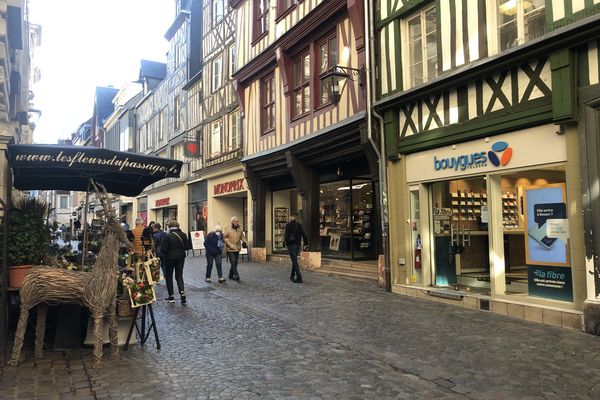 The flowers of the passage coexist with the big brands in the rue du Gros Horloge in Rouen.