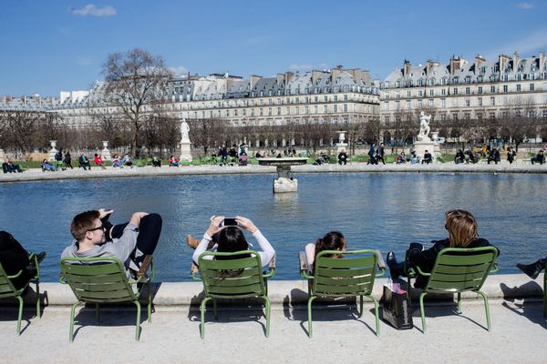 Des visiteurs se prélassent au jardin des Tuileries à Paris.