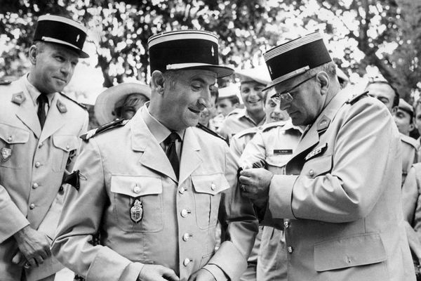 Photo prise le 08 juillet 1970 à Hyères. Louis de Funès reçoit du Colonel Garandeau les insignes de l'unité du 405e régiment d'artillerie anti-aérienne où une série de scènes du film de Jean Girault "Le gendarme en balade" a été tournée et le titre de "canonnier d'honneur" pour sa conduite exemplaire sous les feux des projecteurs.