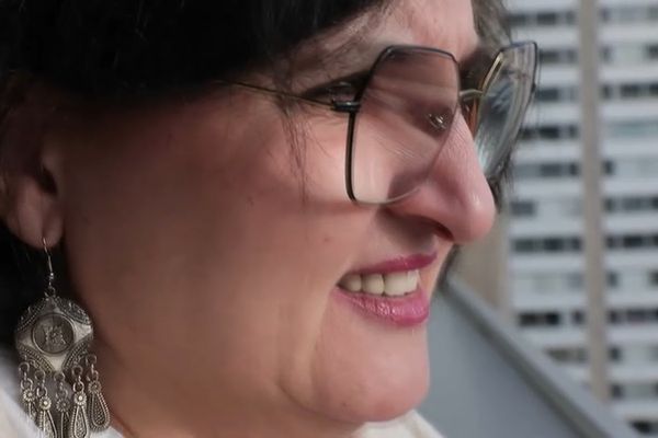 Virginie regarde son quartier sur le balcon de Monique