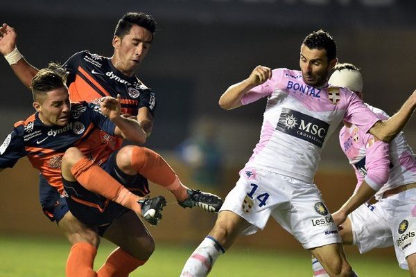 Les footballeurs Montpellierains Anthony Mounier (à gauche) et l'argentin Lucas Barrios (centre) à la lutte pour le ballon contre le milieu de terrain d'Evian Cedric Barbosa