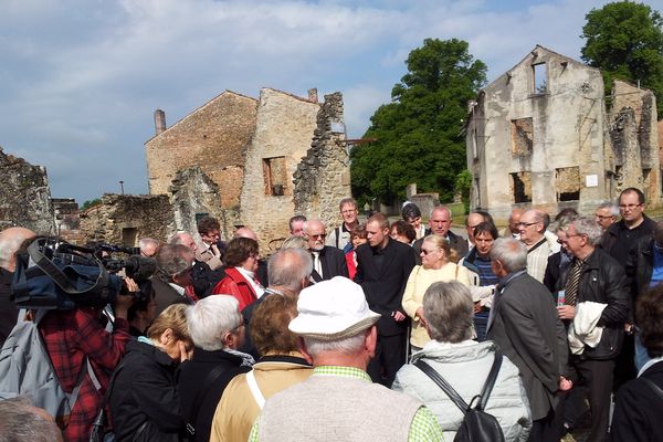 Robert Hebras faisant visiter le village martyr d'Oradour-sur-Glane à un groupe d'allemands et de polonais.