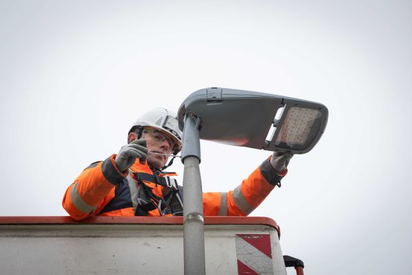 Un technicien installe des LED sur un lampadaire.