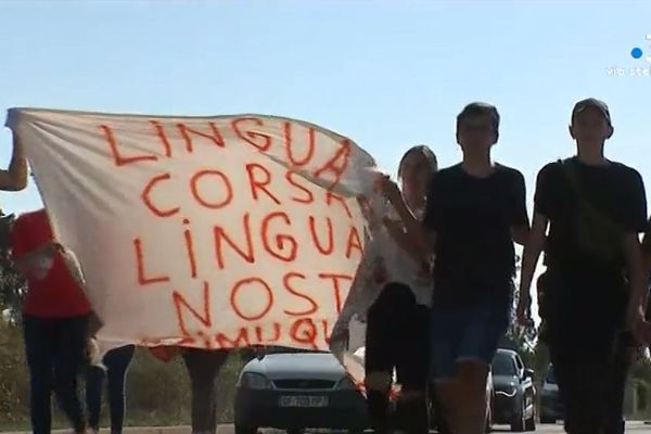 Des lycéens et parents défilent avec une pancarte "Lingua corsa, lingua nostra" et le #SimuQuì après la plainte déposée par la rectrice à l'encontre de Joseph Colombani.