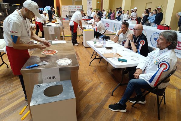 Un candidat confectionne sa pizza devant un jury attentif, Palais de l'Europe à Menton, le 5 novembre 2024.