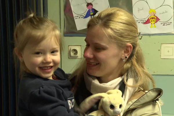 Kamila, 3 ans, dans les bras de sa maman.