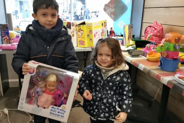 Ethan, 6 ans, et sa petite soeur Ambre, 3 ans, distribuent les jouets récoltés aux familles dans le besoin. 