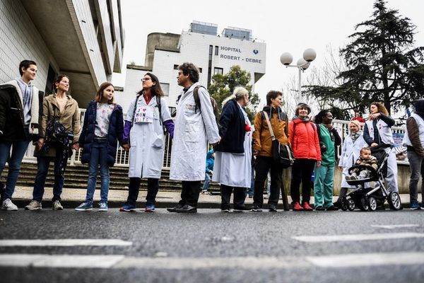 Des centaines de personnes ont formé une chaîne humaine autour de l'hôpital Robert Debré (Paris XIXe) pour défendre l'hôpital public.