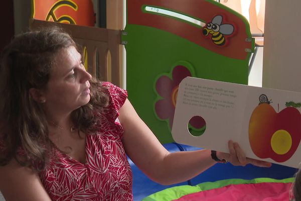 À Saint-Jean-d'Angely, en Charente-Maritime, une assistante maternelle lit un livre à un groupe de petits de moins de 4 ans (septembre 2024).