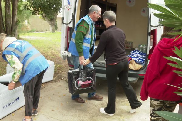 Pascale Houzaye (au centre, en noir) reçoit des denrées du Solidaribus.