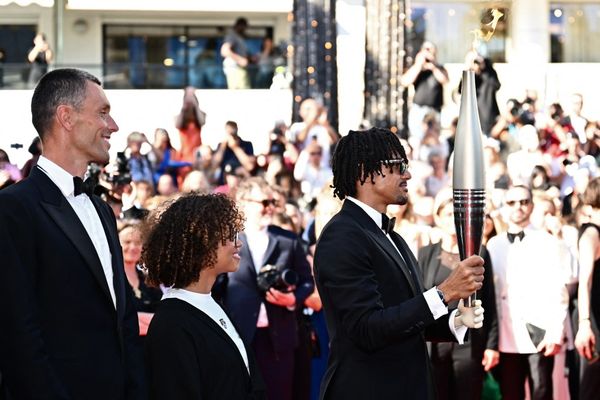 Arnaud Assoumani avec la torche Olympique pour la montée des marches pour aller voir le documentaire "Olympiques ! La France des jeux".