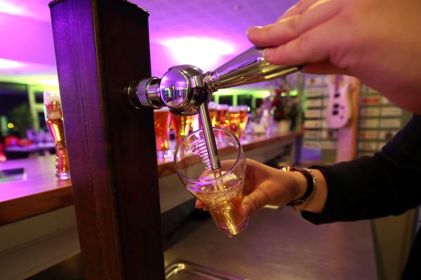 Un barman sert une pinte dans un bar - Photo d'illustration