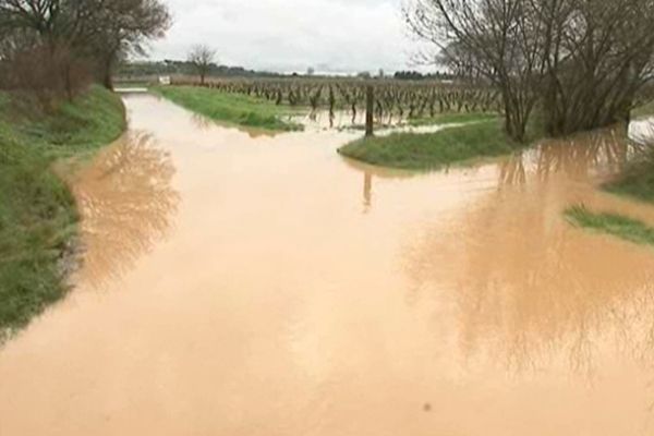 Le ruisseau gonflé par la pluie a envahi la route qui était interdite à la circulation.