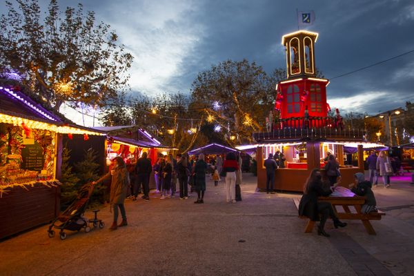 Les gens se promènent au marché de Noël de Cannes.