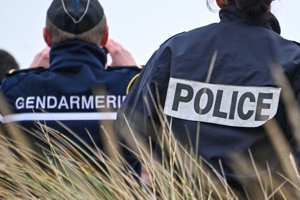 Un gendarme et un policier observant la côte à Oye-Plage, près de Calais.