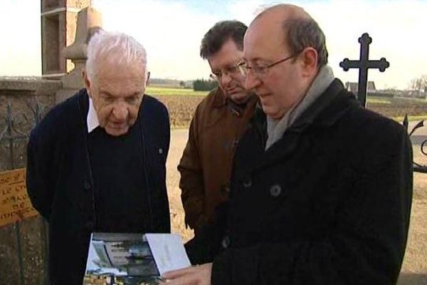 Les auteurs Bernard Xibaut et Jean-François Kovar présentent leur livre à l'ancien prêtre de l'église de Hipsheim.