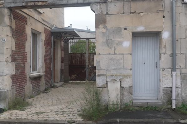 Devant la porte d'entrée de l'immeuble où résidait la victime du meurtre.