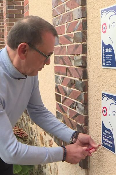 Gilles Rousselet, maire de Montharville, accrochant la Marianne du civisme