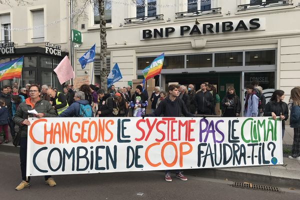 Les manifestants sont passés devant une banque pour dénoncer une responsabilité de la finance dans le dérèglement climatique. 