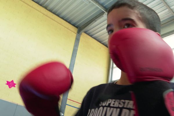 Anouar, 8 ans, boxe en martelant les mots qu'il a écrit sur le harcèlement à l'école.