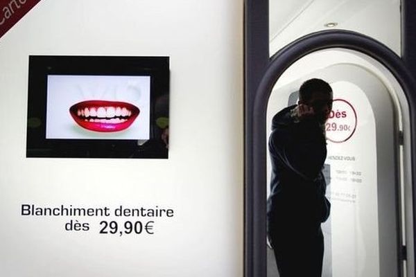 Une personne sort d'une boutique qui propose un service de blanchiment des dents, le 24 novembre 2011 à Paris
