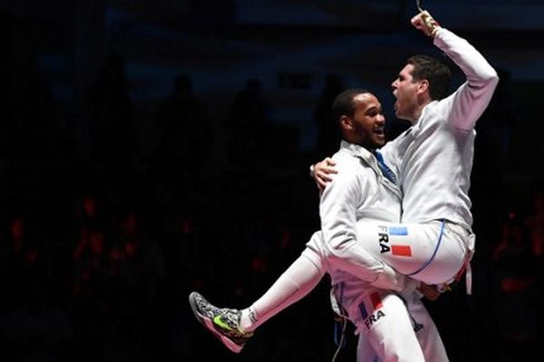 La joie de Gauthier Grumier, qui saute dans les bras de son coéquipier Daniel Jerent, lors de la victoire de l'équipe de France d'épée aux J.O de Rio, le 14 août 2016.