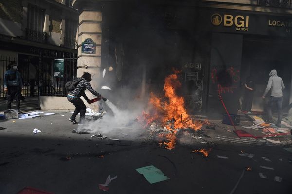 Un manifestant tente d'éteindre un départ de feu boulevard Voltaire ce dimanche 1er mai.