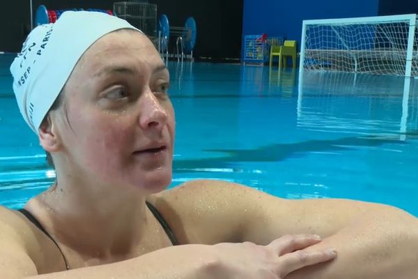 Louise Guillet, capitaine de l'équipe de France de water-polo, reprend son souffle sur le bord de la piscine de l'INSEP (Institut national du sport, de l'expertise et de la performance)