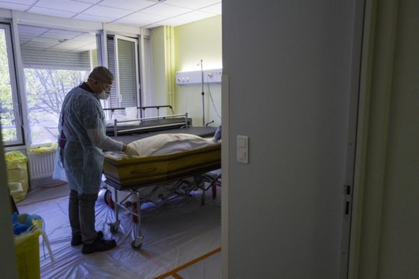 ILLUSTRATION. Des employés de compagnie funéraire sortent le cercueil d'une victime de la Covid-19 dans un hôpital de Mulhouse. (5 avril 2020) 