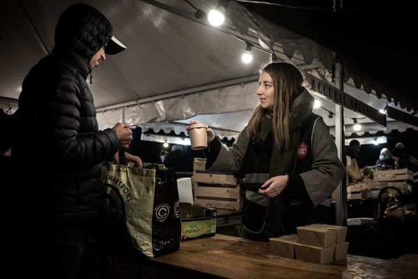 Une bénévole des Gratuits Gironde Solidarité propose un gobelet de soupe ou de café, lors d'une maraude, le 13 décembre 2022 à Bordeaux.