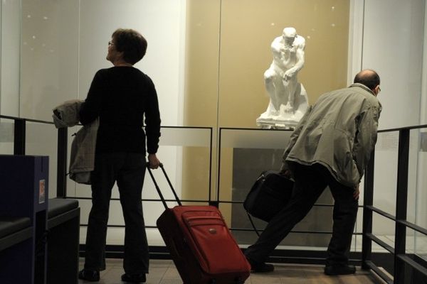 Des passagers passent devant "Le Penseur" de Rodin dans l'espace culturel de l'aéroport de Roissy Charles-de-Gaulle. 