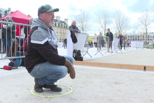 Un participant au championnat du monde de pétanque en moufles affine sa stratégie, samedi 30 mars, à Caen.