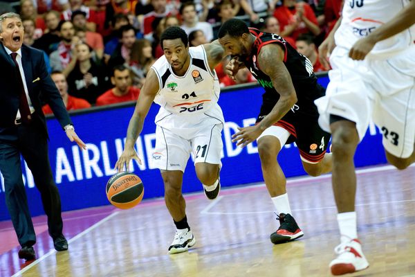 Tony Taylor (en blanc) en pleine action face au joueur du Bayern de Munich Bo McCalebb lors d'une rencontre de l'Euroleague en décembre 2014 entre le Bayern et le club polonais Turow Zgorzelec à Munich en Allemagne.