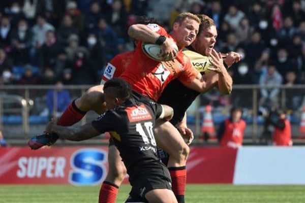 Riaan Viljoen, en rouge, des Sunwolves tacklé par Elton Jantjies et Andries Ferreira (à droite) pendant un match du Super Rugby en 2016.