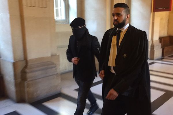 Mounir Meskine, le visage couvert, au moment de son départ du palais de justice de Paris.