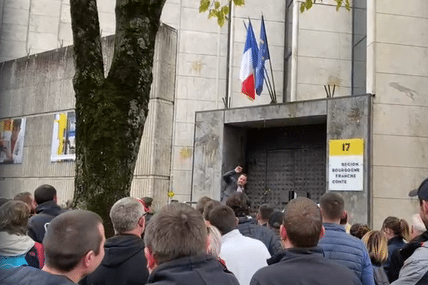 Manifestation des agriculteurs de BFC devant le Conseil régional : le sénateur Jérôme Durain lève le bras pour se protéger de jets d'oeufs.