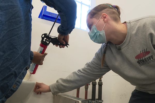 Une professionnelle donne ses conseils aux participantes. Objectif : apprendre à faire un joint silicone.